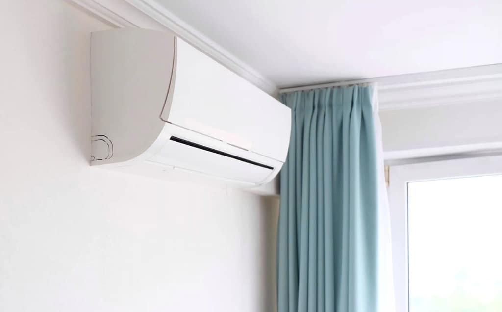 Modern ductless air conditioner installed on a white interior wall.