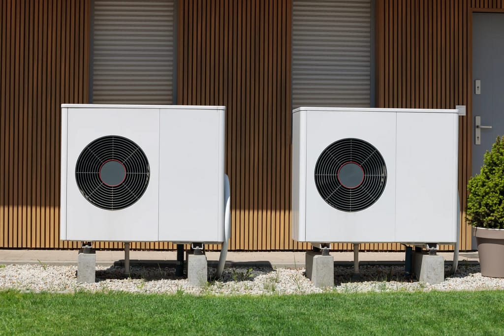 Two heat pump units installed outside a modern home in New Jersey.